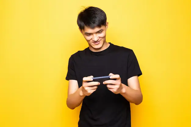 young guy playing mobile games